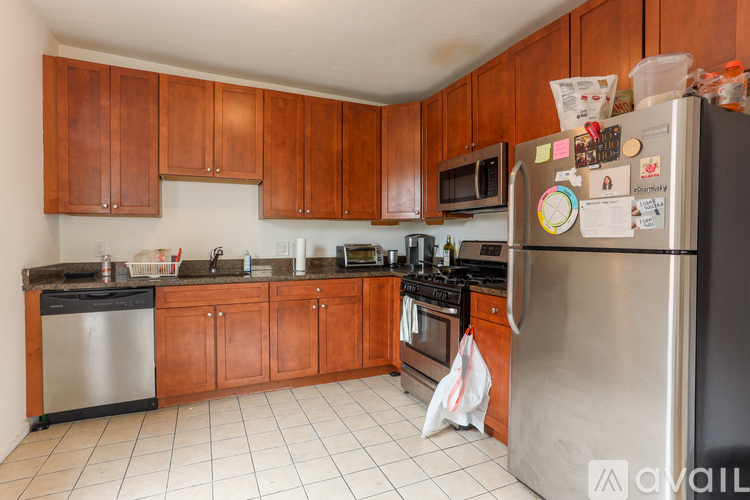 A kitchen with wooden cabinets and a stainless steel refrigerator.