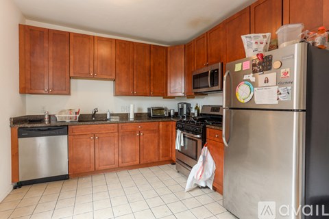 A kitchen with wooden cabinets and a stainless steel refrigerator.