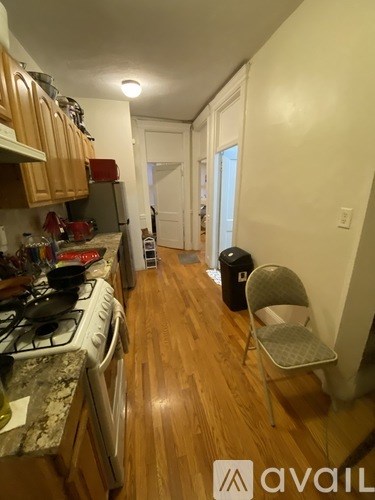 A kitchen with a stove and a chair.