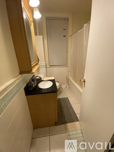 A bathroom with a sink, mirror, and a tiled floor.