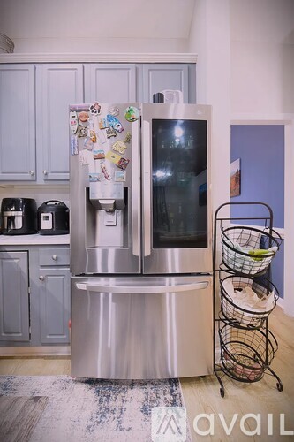 A stainless steel refrigerator with a glass door is in a kitchen.
