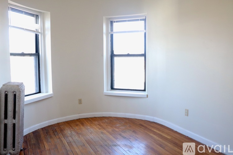 A room with wooden floors and two windows.