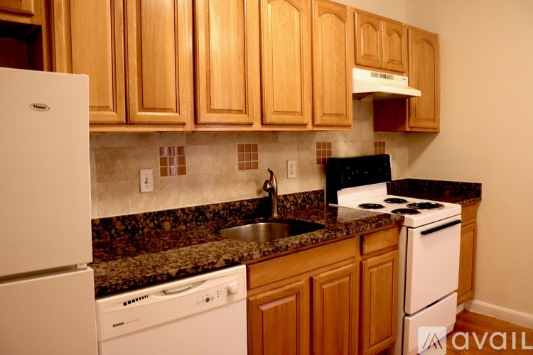 A kitchen with wooden cabinets and a granite countertop.