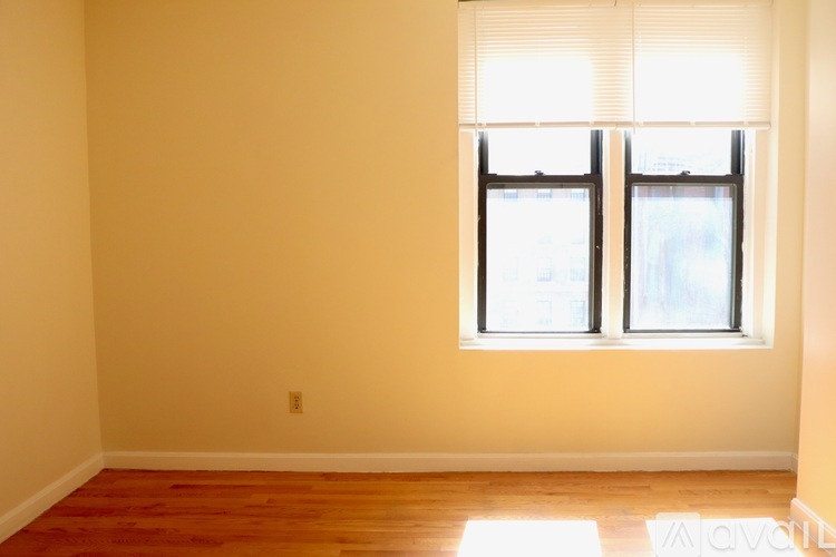 A room with a window and wooden floor.