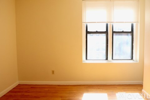 A room with a window and wooden floor.