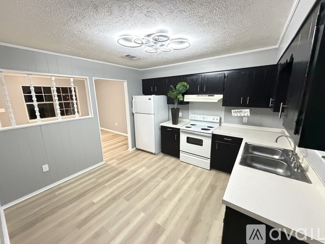 A kitchen with a white fridge and black cabinets.