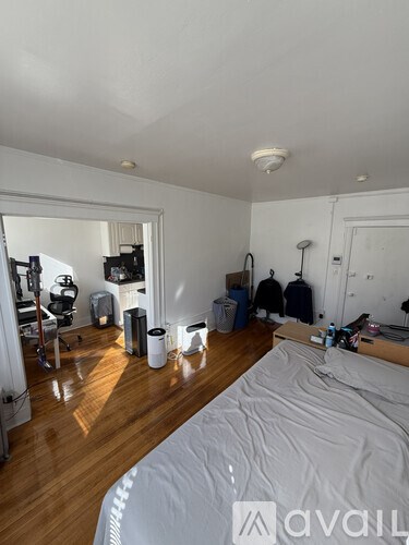 A bedroom with a bed, a desk, and a chair.