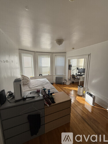 A room with a bed, a dresser, and a window.