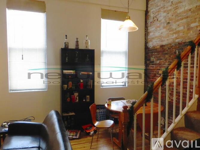 A living room with a black leather chair and a wooden table.