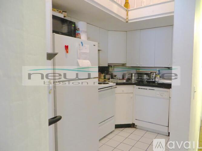 A kitchen with white cabinets and appliances is available for rent.
