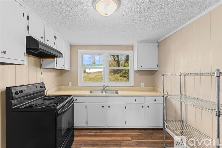 A kitchen with white cabinets and a black stove top oven.