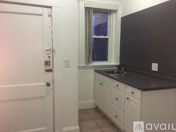 A white door with a window above a sink in a kitchen.