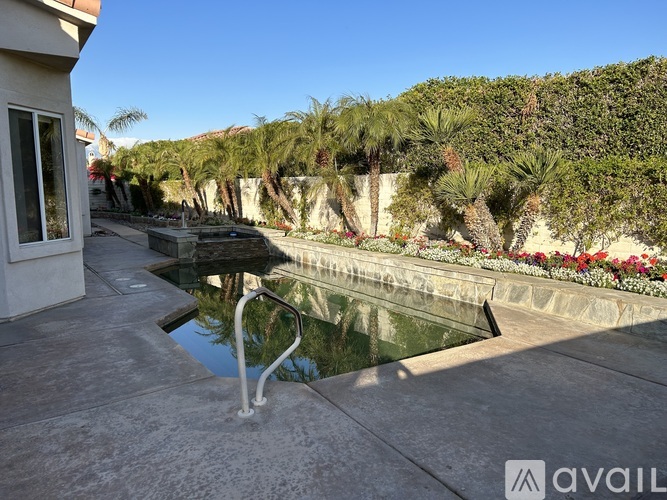 A pool surrounded by a concrete wall and a metal railing.