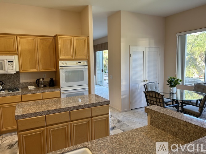 A kitchen with wooden cabinets and granite countertops.