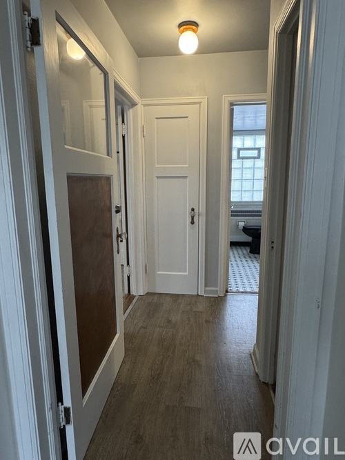 A hallway with a white door and a brown door.