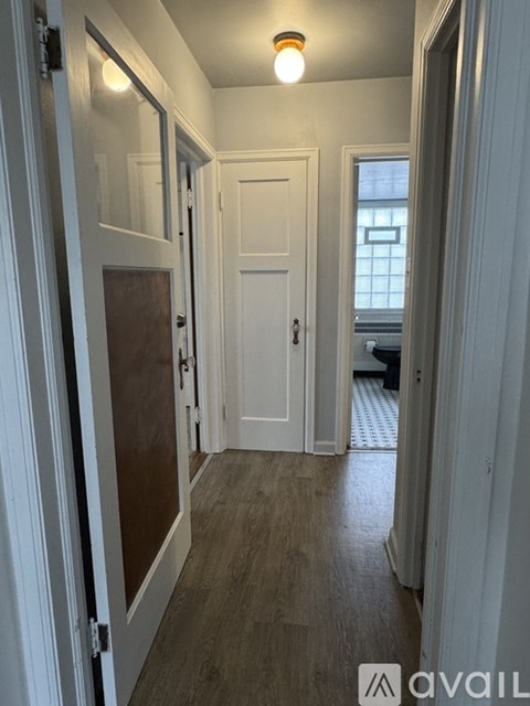 A hallway with a white door and a brown door.