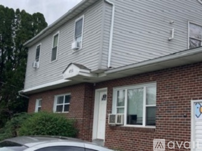 A house with a white garage door and a brick wall.
