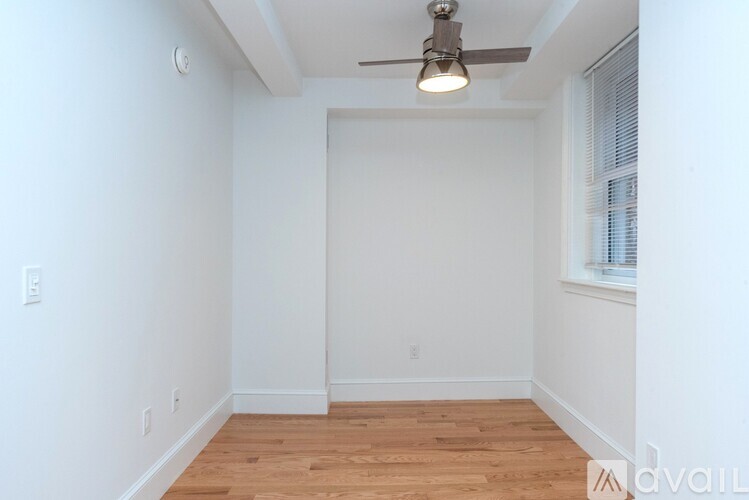 A room with a ceiling fan and wooden flooring.