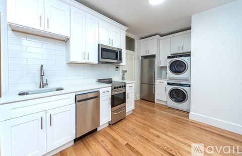 A kitchen with white cabinets and stainless steel appliances.