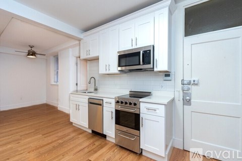 A kitchen with white cabinets and a stainless steel oven.