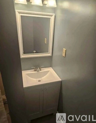 A bathroom with a sink and mirror.
