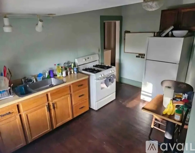 A kitchen with a white stove and wooden cabinets.