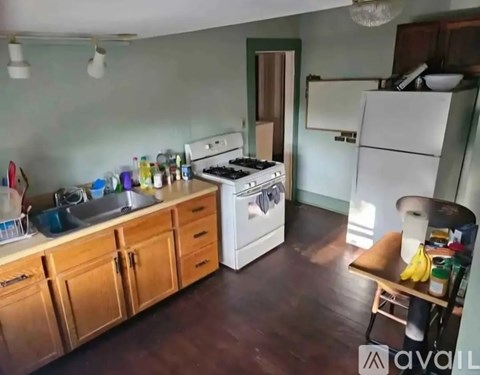 A kitchen with a white stove and wooden cabinets.