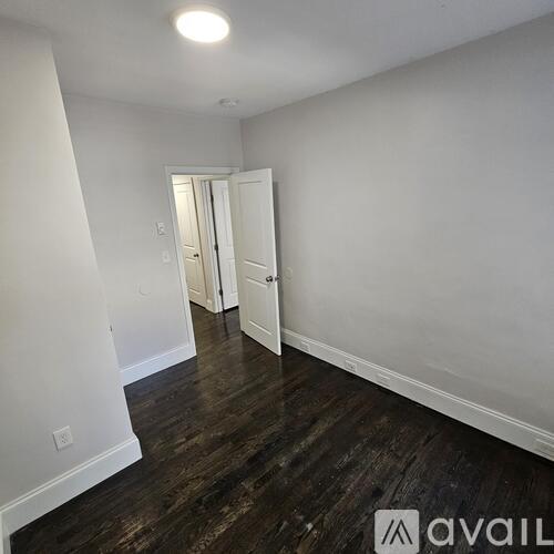 A room with wood flooring and white walls.