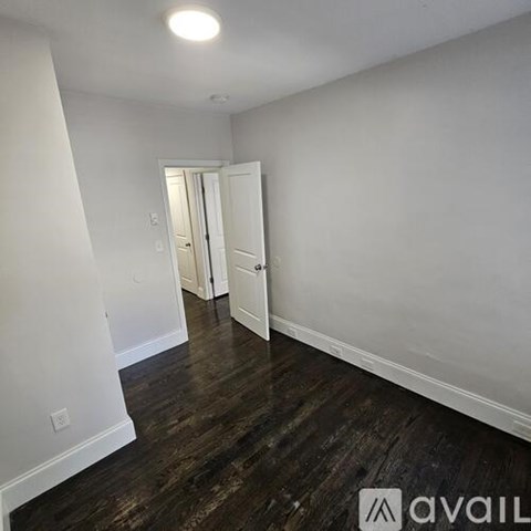 A room with wood flooring and white walls.