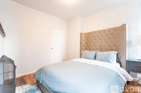 A bedroom with a large bed and a tufted headboard.