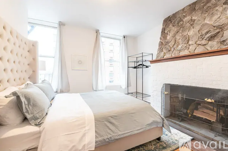 A bedroom with a large bed and a fireplace.