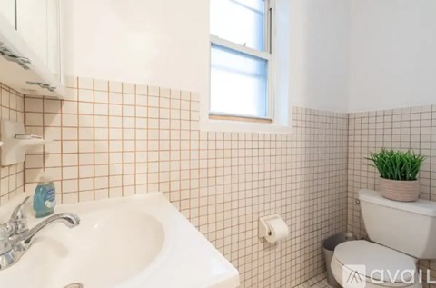 A bathroom with a white sink and a toilet.