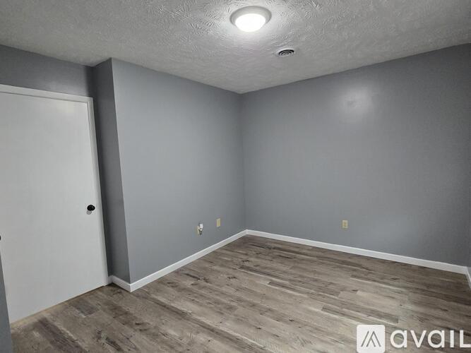 A room with a white door and grey walls.