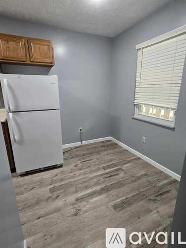 A kitchen with a white fridge and wooden cabinets.