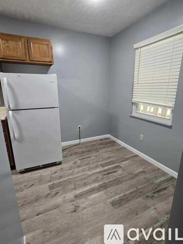 A kitchen with a white fridge and wooden cabinets.