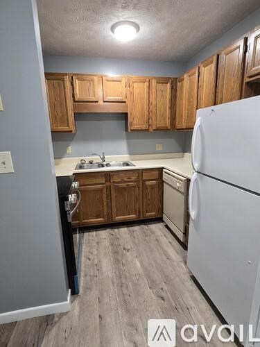 A kitchen with wooden cabinets and a white refrigerator.