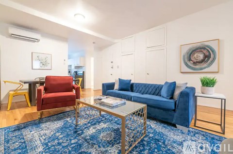 A living room with a red chair, blue sofa, and a patterned rug.