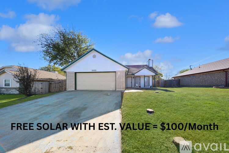 A house with a driveway and a sign that says "FREE SOLAR WITH EST. VALUE = $100/Month".