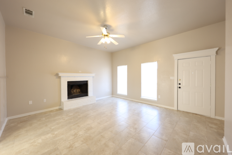 A spacious room with a fireplace and a ceiling fan.