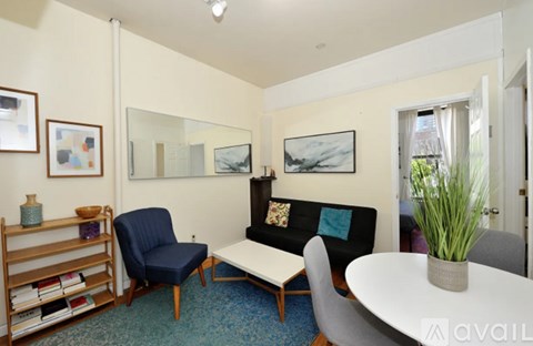 A living room with a blue chair and a white table.