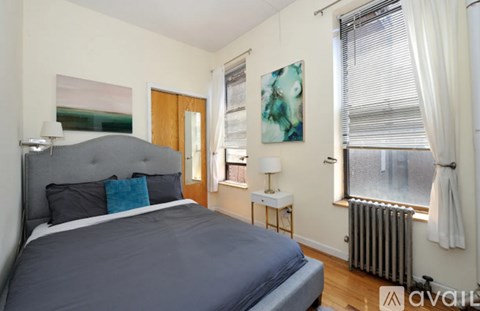 A bedroom with a large bed and a painting on the wall.