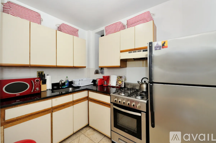 A kitchen with a refrigerator, microwave, and oven.