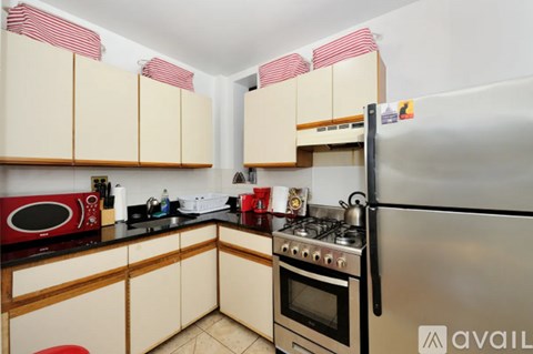 A kitchen with a refrigerator, microwave, and oven.