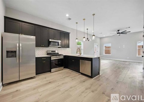 A modern kitchen with dark wood cabinets and stainless steel appliances.