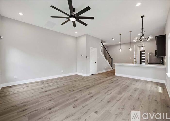 A spacious room with a ceiling fan and wooden flooring.