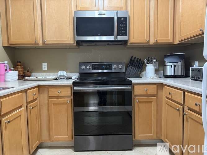 A kitchen with wooden cabinets and a black stove top oven.