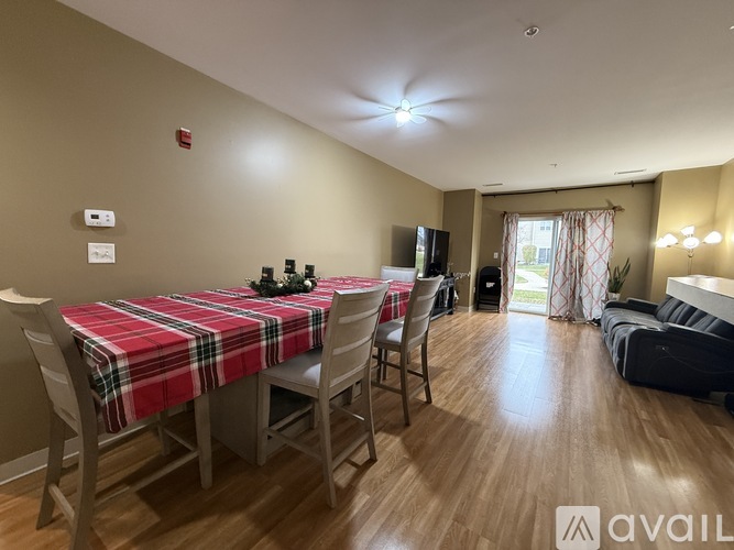 A dining room with a table set for two and a couch in the background.