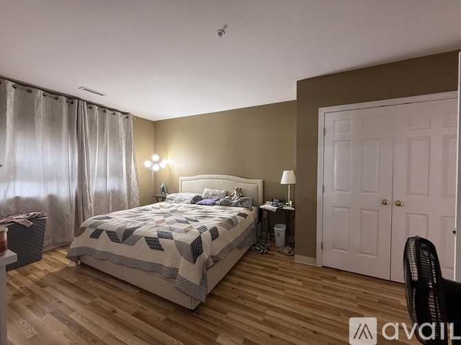 A bedroom with a large bed and a chair.