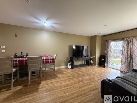 A living room with a television, a couch, and a dining table set up.