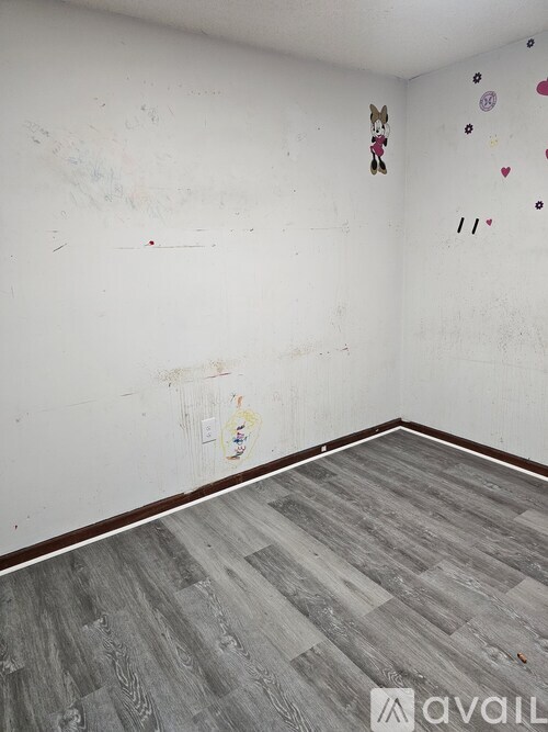 A room with a white wall and a wooden floor.